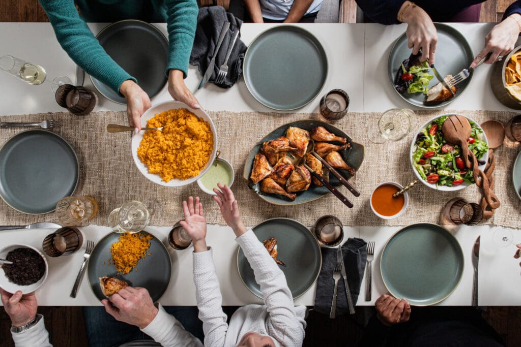 Family gathering around a table sharing food.